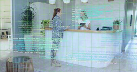 Soldier in uniform using technologies at reception desk in modern office