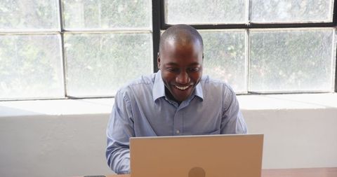 Business Professional Celebrating Success at Desk by Window