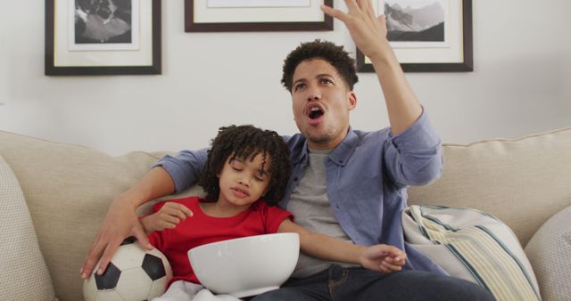 Father and Son Watching Soccer Game with Excitement on Living Room Couch - Download Free Stock Images Pikwizard.com