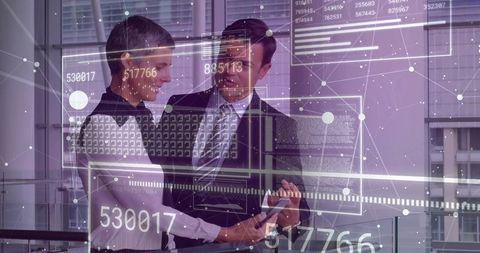 Business Colleagues Analyzing Data with Tablet in Futuristic Office