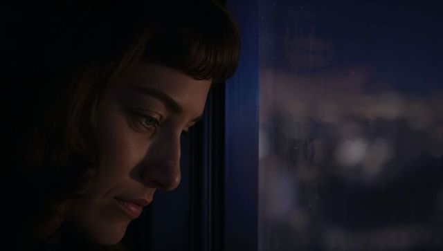 Woman pressing face to rainy night window gazing at city lights, moody contemplation