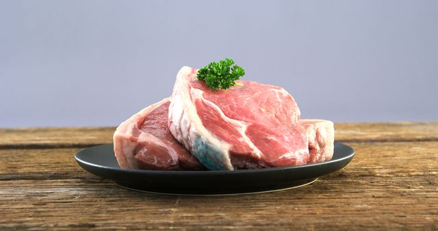 Fresh Raw Pork Chops on Black Plate with Parsley Garnish - Download Free Stock Images Pikwizard.com