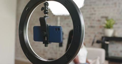 African american creator filming vlog with ring light and smartphone in home studio