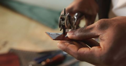 Craftsman's hands creating leather masterpiece gear workshop