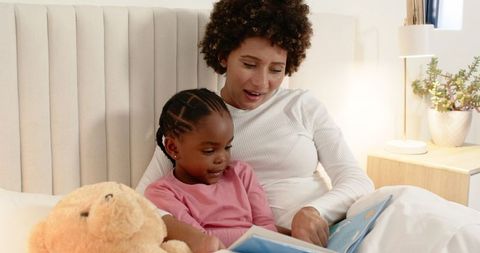 Mother and Daughter Reading Bedtime Story in Cozy Bedroom