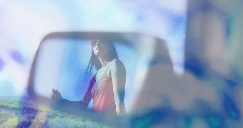 Reflective Woman in Car Mirror with Scenic Landscape