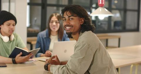 Smiling African American Students Collaborating with Friends at Modern Coworking Table