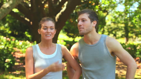 Athletic Couple Relaxing After Running in Forest