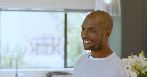 Smiling Proudman Relaxing in Modern Kitchen with Natural Lighting