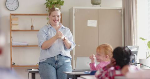 Teacher Instructing Young Students in Bright Classroom Environment