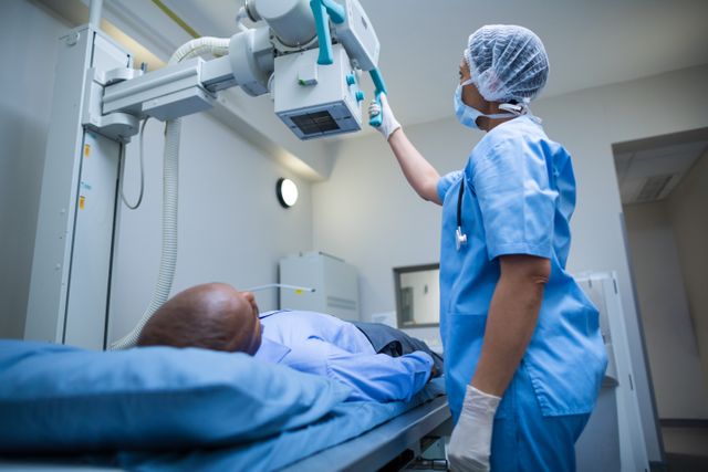 Female doctor sets up the machine to x-ray over patient in hospital
