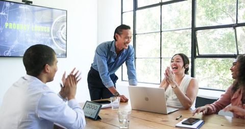 Diverse Team Celebrating Success in Modern Office Meeting