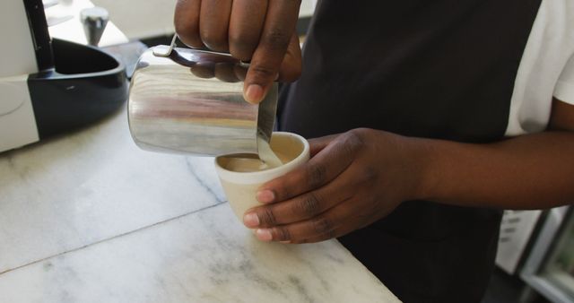 Close up of african american male barista making coffee at cafe. small independent cafe business.