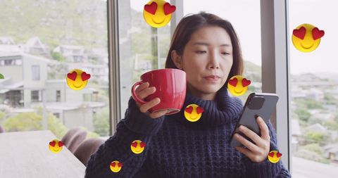 Woman Enjoying Coffee with Smartphone Surrounded by Emoji Hearts