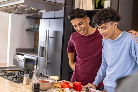 Two friends cooking together in modern kitchen