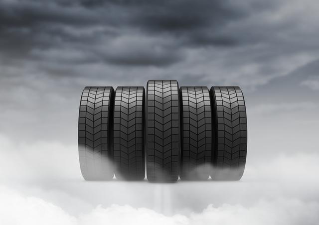 This image of five tires against a cloudy sky can be used for automotive advertisements, tire promotions, vehicle maintenance guides, or transportation-related content. The dramatic sky adds a dynamic and powerful feel, making it suitable for marketing materials and digital campaigns.