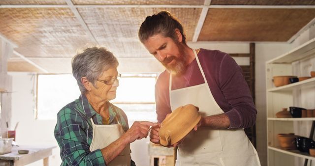 Older Woman Teaching Pottery to Middle-aged Man in Workshop - Download Free Stock Images Pikwizard.com