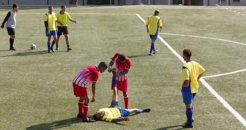 Soccer Player Receiving Help After Colliding on Field