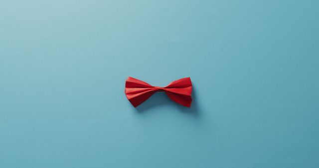 Image of red bow tie lying on blue background. men fashion, clothes, accessories and elegance concept.