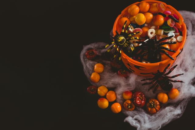 High angle view of orange bucket with food and decoration over black background