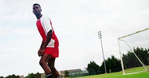 Young Athlete Striking Ball on Soccer Field Against Clear Sky - Download Free Stock Images Pikwizard.com
