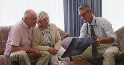 Senior Couple Consulting Male Doctor with X-Ray