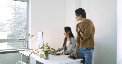 Asian Colleagues Collaborating in Modern Office Environment