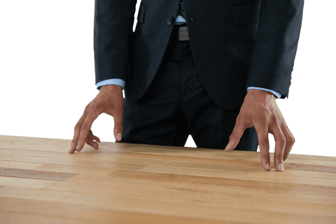 Businessman in Suit Gesturing Over Transparent Wooden Table