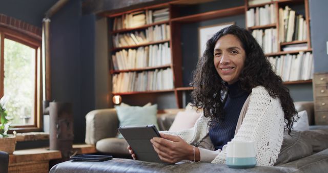 Smiling Woman Using Tablet in Cozy Living Room with Home Library - Download Free Stock Images Pikwizard.com