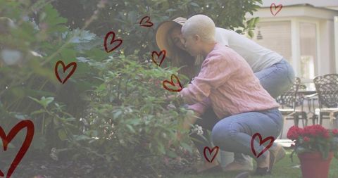 Loving couple pruning garden shrub together outdoors