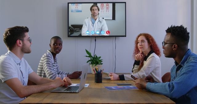 Diverse team having remote consultation with doctor on video call in office - Download Free Stock Images Pikwizard.com