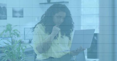 Financial analyst examining market trends with laptop and charts