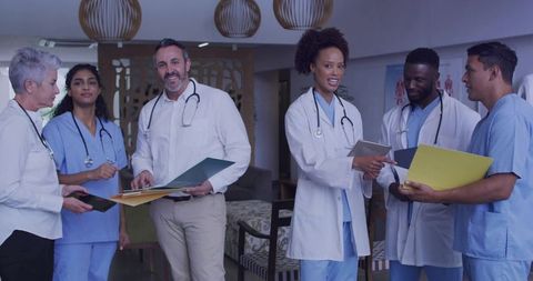 Multidisciplinary medical team reviewing patient charts and collaborating in clinic lounge