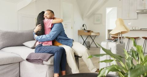 Joyful Reunion: Couple Embracing Before Travel, Packed Suitcase Ready