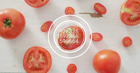 Halved tomato with circular hud overlay on wood board, whole tomatoes and cherry slices