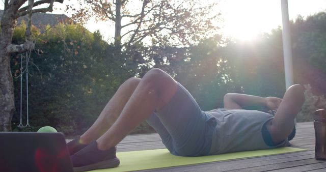 Man Exercising Outdoors on Mat with Laptop Nearby at Sunset - Download Free Stock Images Pikwizard.com