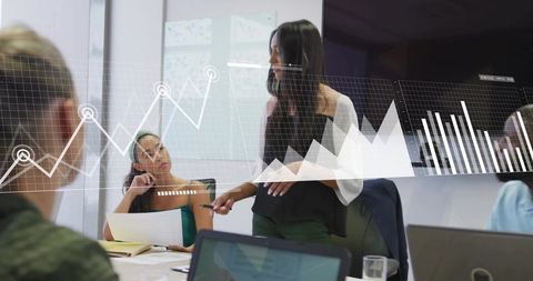 Businesswoman presenting analytics with augmented reality overlays during team meeting