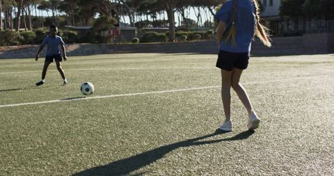 African teenage teammates practicing soccer on artificial turf during outdoor training