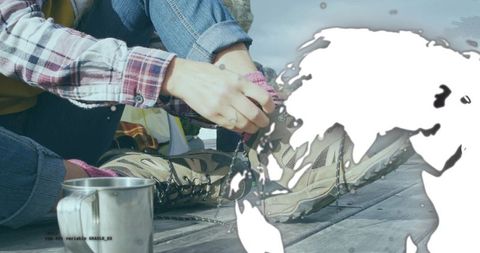 Woman tying hiking boots on dock with earth overlay