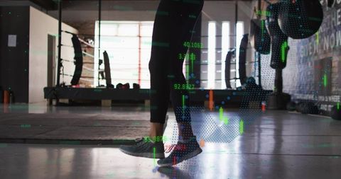 Female Athlete Balancing on Toes in Sunlit Gym with Digital Stock Market Data Overlay