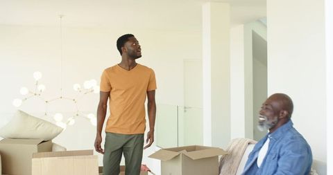 Father and Son Unpacking Boxes in Bright Modern Living Room