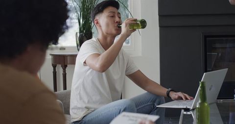 Friends planning bachelor party relaxing with drinks at home