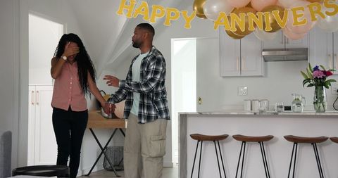 Surprised couple celebrating at home for anniversary party
