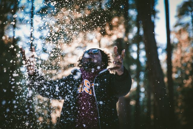 Man playing in snow amid winter forest - Download Free Stock Images Pikwizard.com