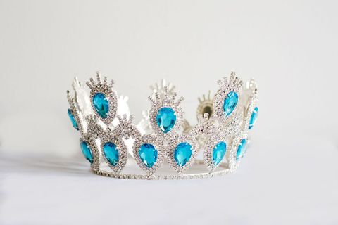Elegant silver king crown tiara with blue gemstones on white background
