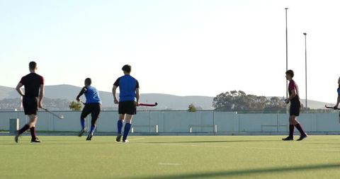 Male field hockey players compete on artificial turf