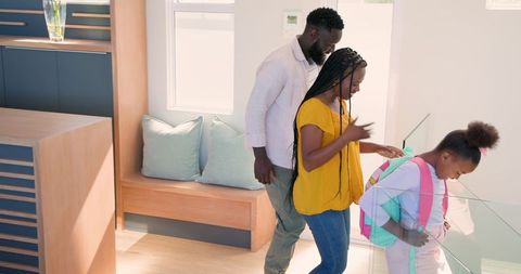 Family and daughter with backpack embracing in morning routine