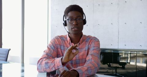 Young Professional Sitting at Desk in Office with Headset - Download Free Stock Images Pikwizard.com