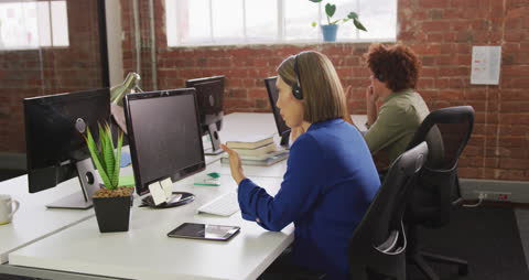 Colleagues in Video Call Wearing Headsets at Office Desks