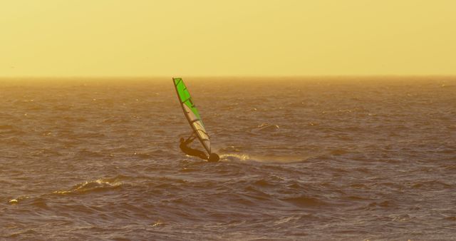 Windsurfer navigating waves at sunset in golden sea - Download Free Stock Images Pikwizard.com